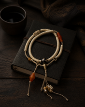 Load image into Gallery viewer, A Quiet Return beaded bracelet with pale beads and warm orange accent — image 04