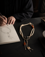 Load image into Gallery viewer, A Quiet Return beaded bracelet with pale beads and warm orange accent — image 07
