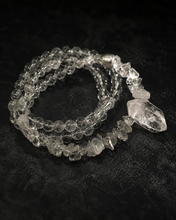 Load image into Gallery viewer, NORBU OBJECTS product image direction: a neck-worn line with a central pendant or focal detail; clear and translucent tones; deep highland light; a map archivist in a quiet Lhasa guesthouse; collector archive.
